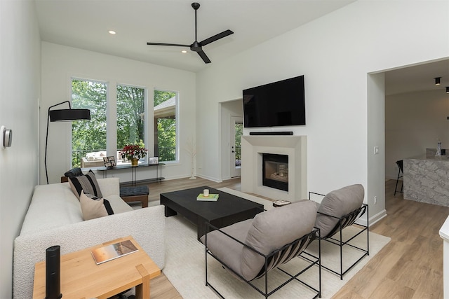 1286 Glen Oaks Dr, West Des Moines, IA 50266 - living area with ceiling fan, light wood-style floors, a glass covered fireplace, and recessed lighting