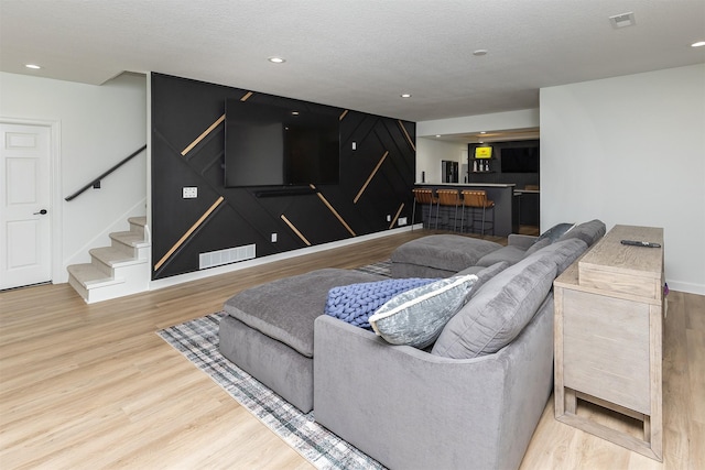 1286 Glen Oaks Dr, West Des Moines, IA 50266 - living room featuring bar, wood finished floors, stairway, and recessed lighting