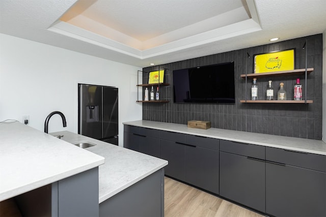 1286 Glen Oaks Dr, West Des Moines, IA 50266 - kitchen with refrigerator with ice dispenser, open shelves, light countertops, backsplash, and light wood-type flooring