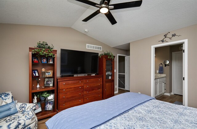690 SE Driftwood Ln, Waukee, IA 50263 - bedroom with wood finished floors, vaulted ceiling, a textured ceiling, ceiling fan, and ensuite bath