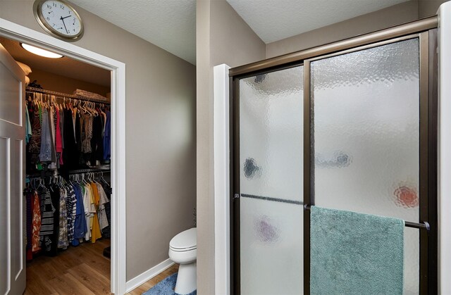 690 SE Driftwood Ln, Waukee, IA 50263 - bathroom with wood finished floors, a shower stall, and a spacious closet
