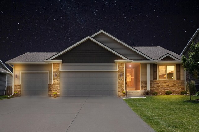 690 SE Driftwood Ln, Waukee, IA 50263 - view of front of home with a garage, stone siding, concrete driveway, and a lawn
