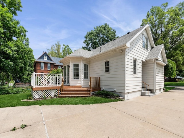 3918 11th St, Des Moines, IA 50313 - rear view of property featuring a wooden deck, a shingled roof, a yard, and driveway