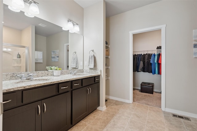 523 S Bluestone Way W, Des Moines, IA 50266 - bathroom with a spacious closet, double vanity, a stall shower, and tile patterned floors
