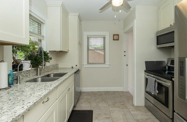 1346 48th St, Des Moines, IA 50311 - kitchen featuring stainless steel appliances, a ceiling fan, white cabinets, and light stone counters