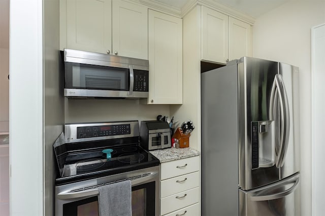 1346 48th St, Des Moines, IA 50311 - kitchen featuring appliances with stainless steel finishes, light stone counters, and white cabinetry