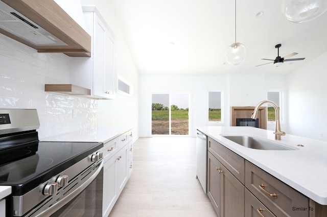 2410 NE 6th St, Grimes, IA 50111 - kitchen featuring appliances with stainless steel finishes, extractor fan, decorative backsplash, light wood-type flooring, and light countertops