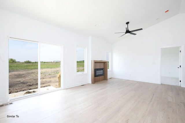 2410 NE 6th St, Grimes, IA 50111 - unfurnished living room with a glass covered fireplace, light wood-style floors, ceiling fan, and high vaulted ceiling