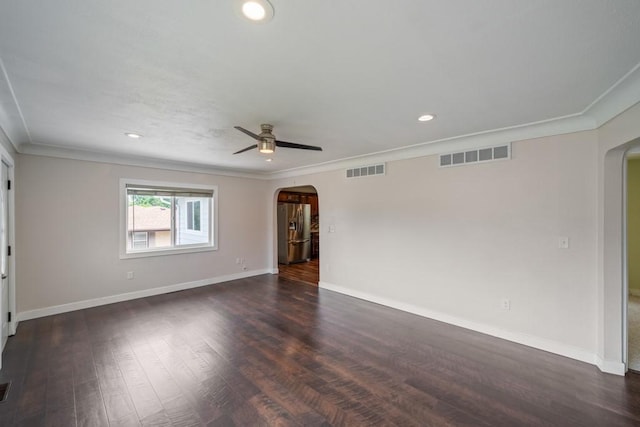 2560 E Sheridan Ave, Des Moines, IA 50317 - spare room with arched walkways, crown molding, dark wood-style floors, recessed lighting, and ceiling fan