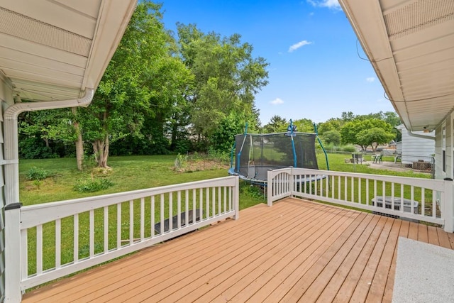 2560 E Sheridan Ave, Des Moines, IA 50317 - deck featuring a trampoline, a yard, and view of wooded area