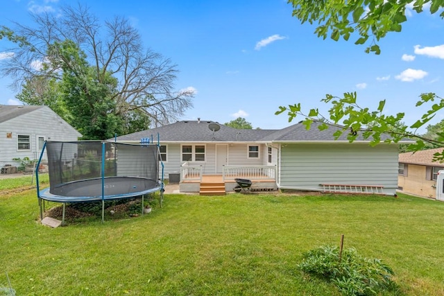 2560 E Sheridan Ave, Des Moines, IA 50317 - rear view of property featuring a trampoline, a yard, and a deck