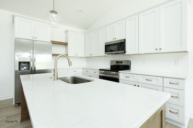 2408 NE 6th St, Grimes, IA 50111 - kitchen featuring appliances with stainless steel finishes, backsplash, a kitchen island with sink, light wood-style flooring, and light countertops