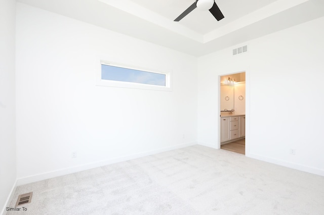 2408 NE 6th St, Grimes, IA 50111 - spare room featuring light colored carpet, ceiling fan, and a raised ceiling