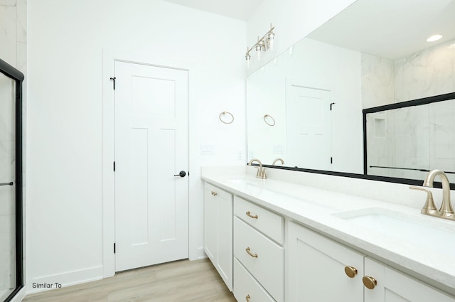 2408 NE 6th St, Grimes, IA 50111 - bathroom featuring double vanity, a shower stall, and wood finished floors