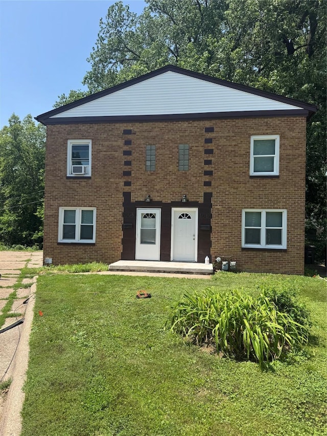1008 Kingman Dr, Des Moines, IA 50311 - view of front of house with brick siding, a front yard, and cooling unit