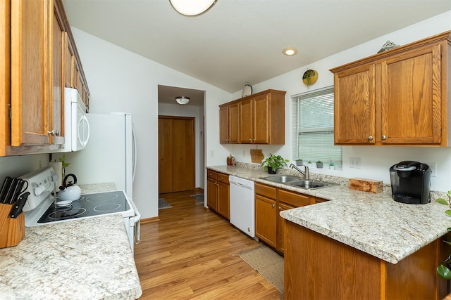 3540 E University Ave, Des Moines, IA 50317 - kitchen featuring white appliances, vaulted ceiling, brown cabinets, light countertops, and recessed lighting