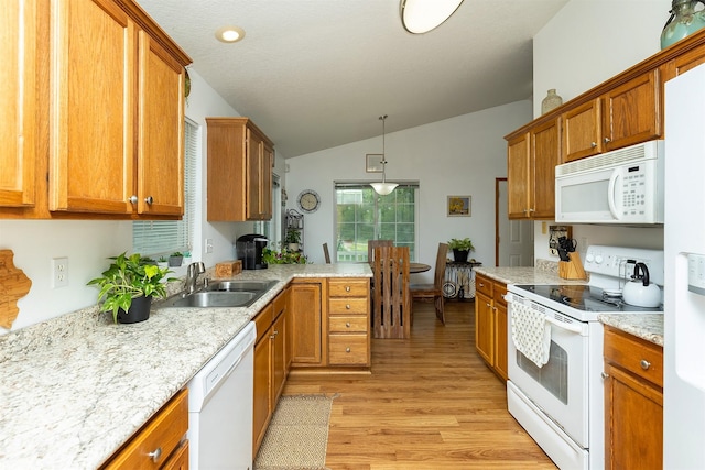 3540 E University Ave, Des Moines, IA 50317 - kitchen featuring white appliances, lofted ceiling, brown cabinetry, light wood-style flooring, and recessed lighting