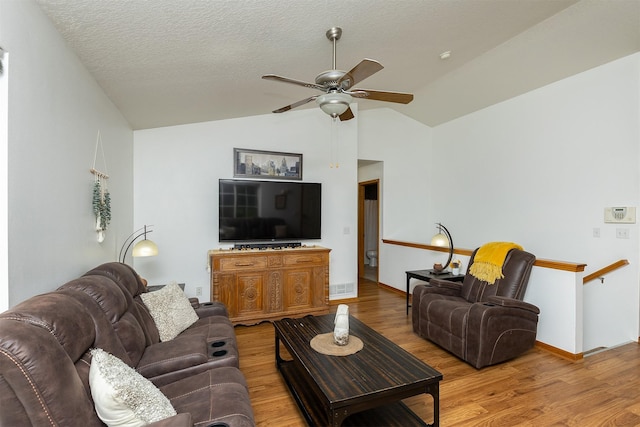 3540 E University Ave, Des Moines, IA 50317 - living room featuring ceiling fan, wood finished floors, vaulted ceiling, and a textured ceiling