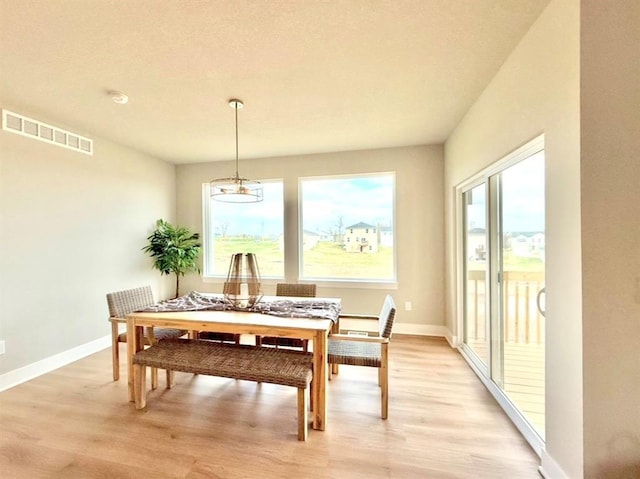 5610 Leyden Ave, Des Moines, IA 50317 - dining room with light wood-style flooring, healthy amount of natural light, and a chandelier