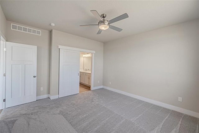5610 Leyden Ave, Des Moines, IA 50317 - unfurnished bedroom featuring light carpet, ensuite bathroom, and a ceiling fan