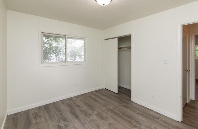 424/426 E Leach Ave, Des Moines, IA 50315 - unfurnished bedroom featuring wood finished floors and a closet
