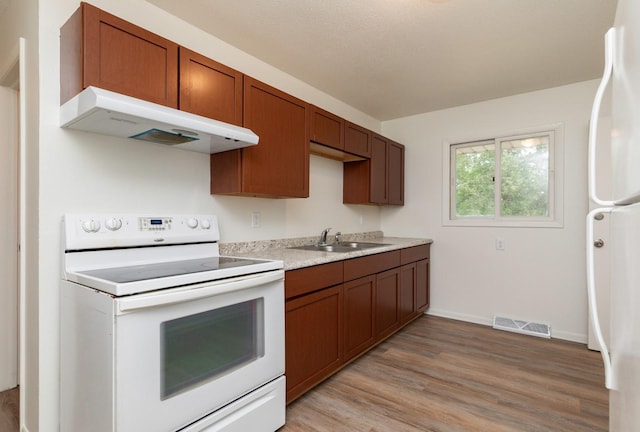 424/426 E Leach Ave, Des Moines, IA 50315 - kitchen featuring white appliances, exhaust hood, light wood finished floors, light countertops, and brown cabinets