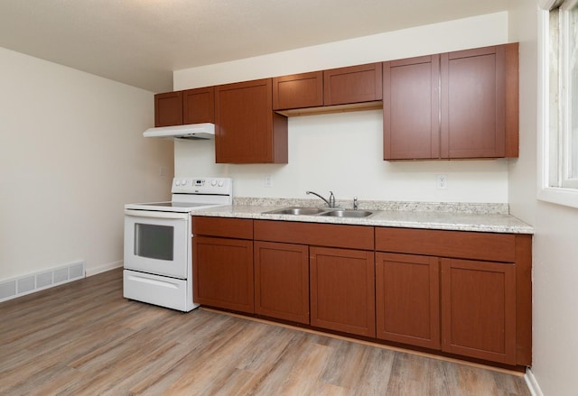424/426 E Leach Ave, Des Moines, IA 50315 - kitchen featuring white electric range, under cabinet range hood, light wood-type flooring, light countertops, and brown cabinetry
