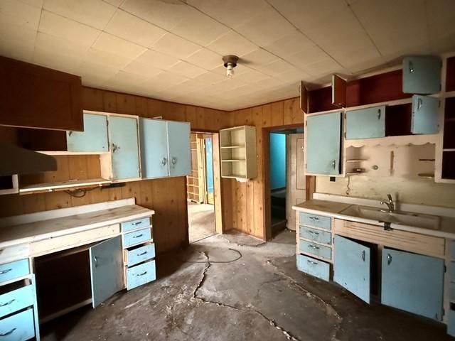 603 N 1st Ave, Marshalltown, IA 50158 - kitchen with open shelves, wooden walls, and concrete floors