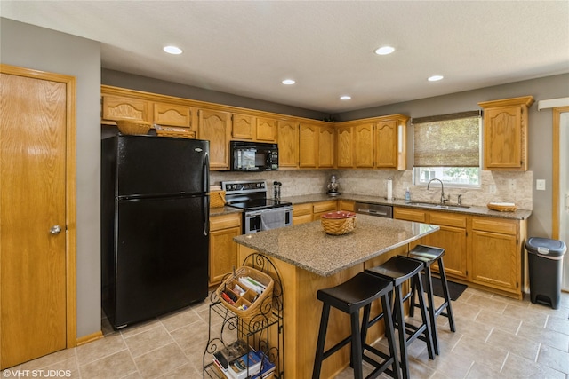 200 Walnut Dr NW, Bondurant, IA 50035 - kitchen with black appliances, backsplash, recessed lighting, a center island, and a kitchen bar