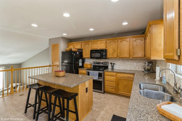 200 Walnut Dr NW, Bondurant, IA 50035 - kitchen with black appliances, a center island, tasteful backsplash, recessed lighting, and a kitchen breakfast bar