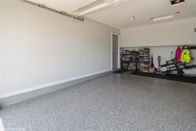 200 Walnut Dr NW, Bondurant, IA 50035 - garage featuring a garage door opener and baseboards