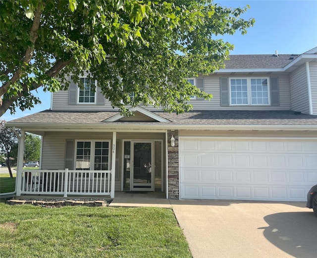 2101 Meadow Ct Unit 304, Des Moines, IA 50320 - view of front of property featuring a porch, concrete driveway, a front lawn, and roof with shingles