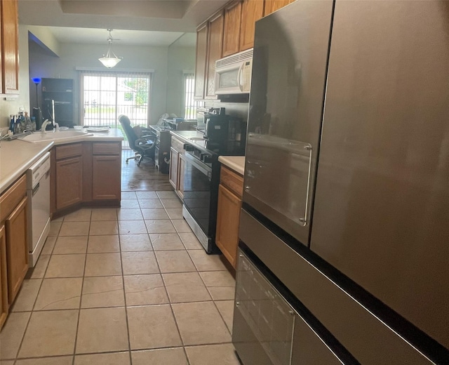 2101 Meadow Ct Unit 304, Des Moines, IA 50320 - kitchen featuring white appliances, a peninsula, light tile patterned floors, light countertops, and brown cabinetry