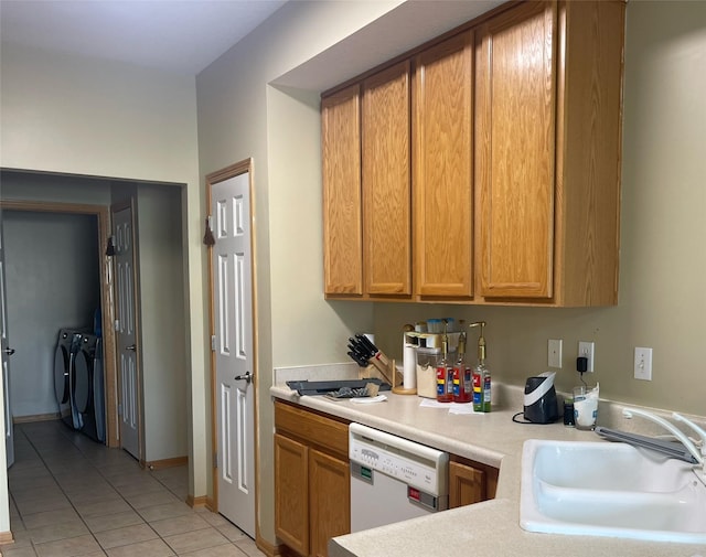 2101 Meadow Ct Unit 304, Des Moines, IA 50320 - kitchen featuring dishwasher, washing machine and clothes dryer, light tile patterned floors, light countertops, and brown cabinetry