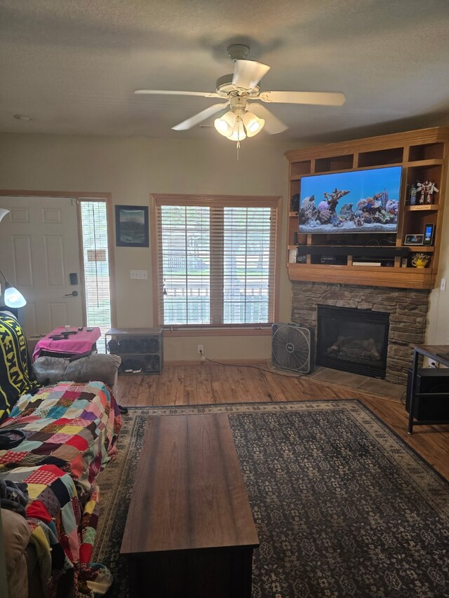 2101 Meadow Ct Unit 304, Des Moines, IA 50320 - living area with wood finished floors, a ceiling fan, and a fireplace