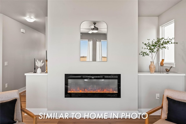 1488 S 91st St, West Des Moines, IA 50266 - detailed view of a glass covered fireplace, a ceiling fan, and wood finished floors