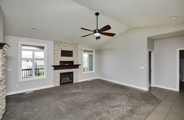 9305 Sugar Creek Cir, West Des Moines, IA 50266 - unfurnished living room featuring ceiling fan, a fireplace, vaulted ceiling, a textured ceiling, and dark tile patterned floors