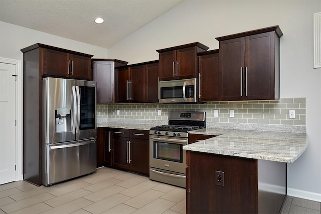 9305 Sugar Creek Cir, West Des Moines, IA 50266 - kitchen with stainless steel appliances, a peninsula, backsplash, dark brown cabinetry, and lofted ceiling