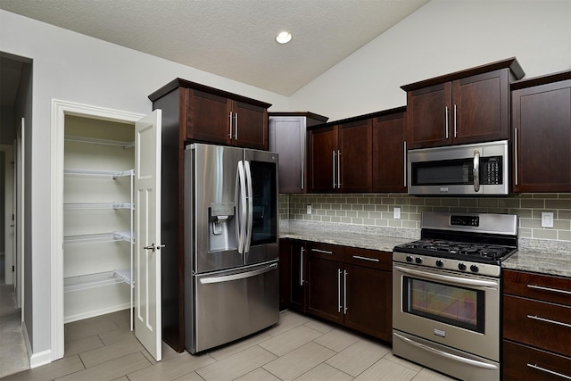 9305 Sugar Creek Cir, West Des Moines, IA 50266 - kitchen with appliances with stainless steel finishes, backsplash, lofted ceiling, light stone countertops, and dark brown cabinets