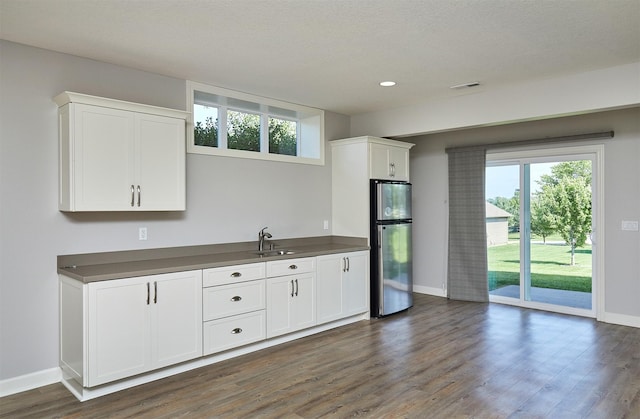 9305 Sugar Creek Cir, West Des Moines, IA 50266 - kitchen with freestanding refrigerator, white cabinetry, healthy amount of natural light, and recessed lighting