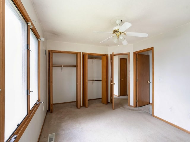 345 13th Ave SW Unit 17, Altoona, IA 50009 - unfurnished bedroom featuring multiple closets, light carpet, and a ceiling fan