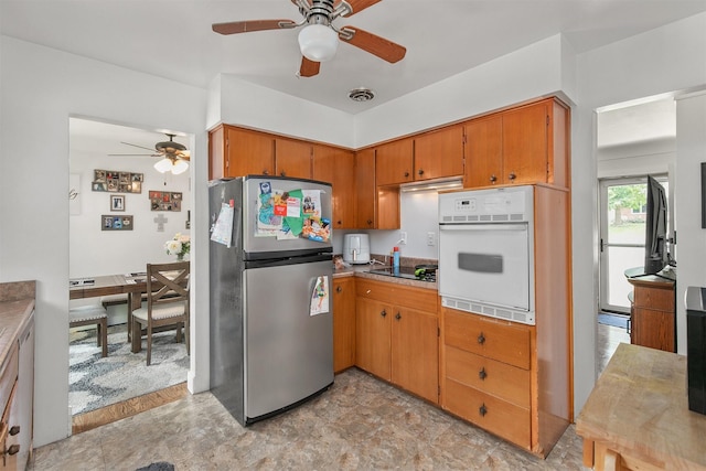 2904 Shadyoak Dr, Des Moines, IA 50310 - kitchen featuring freestanding refrigerator, oven, a ceiling fan, brown cabinets, and black electric stovetop
