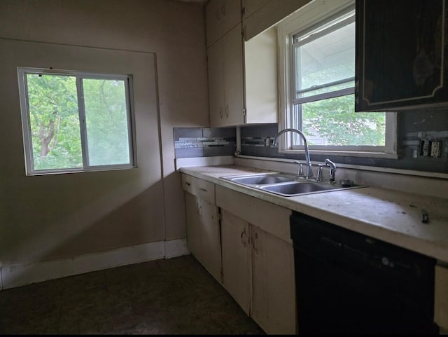 2127 E 13th St, Des Moines, IA 50316 - kitchen with black dishwasher, light countertops, and healthy amount of natural light