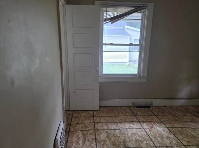 2127 E 13th St, Des Moines, IA 50316 - empty room featuring plenty of natural light and baseboard heating
