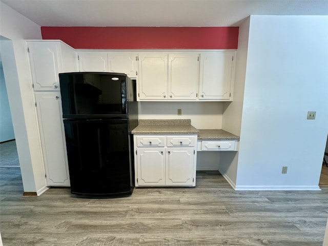 4425 Amick Ave, Des Moines, IA 50310 - kitchen with freestanding refrigerator, white cabinetry, and light wood-style flooring