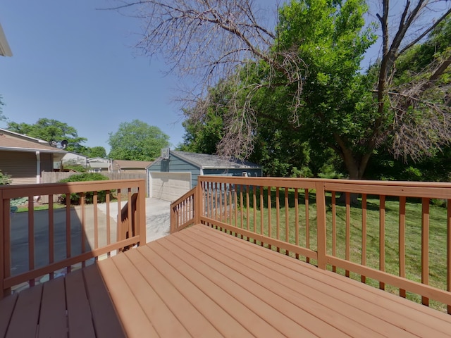 4425 Amick Ave, Des Moines, IA 50310 - wooden deck featuring an outbuilding, a yard, a detached garage, and driveway