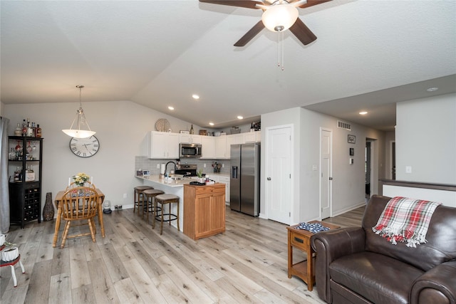 1165 Locust St, Waukee, IA 50263 - living room with lofted ceiling, a ceiling fan, light wood-type flooring, and recessed lighting