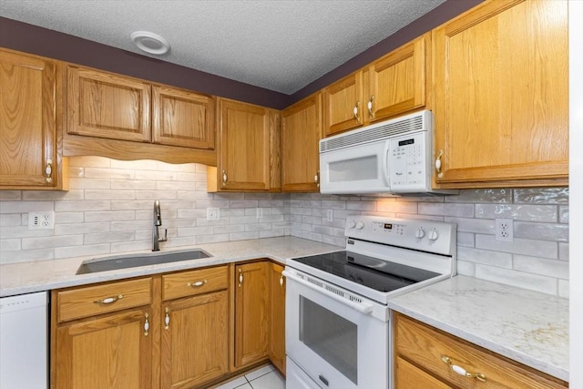 130 NW Georgetown Blvd Unit 4, Ankeny, IA 50023 - kitchen with white appliances, tasteful backsplash, a textured ceiling, brown cabinetry, and light stone countertops