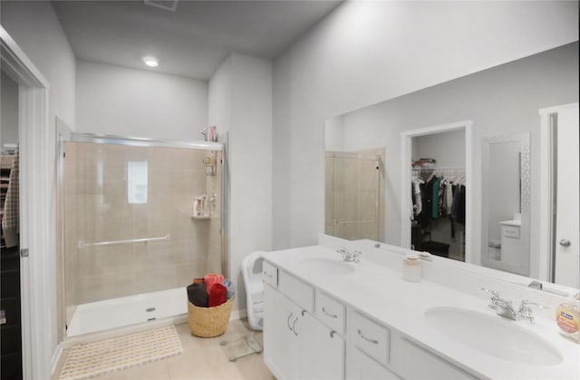 70 Prairie Bluff Dr, Waukee, IA 50263 - bathroom featuring a spacious closet, double vanity, a shower stall, and tile patterned floors