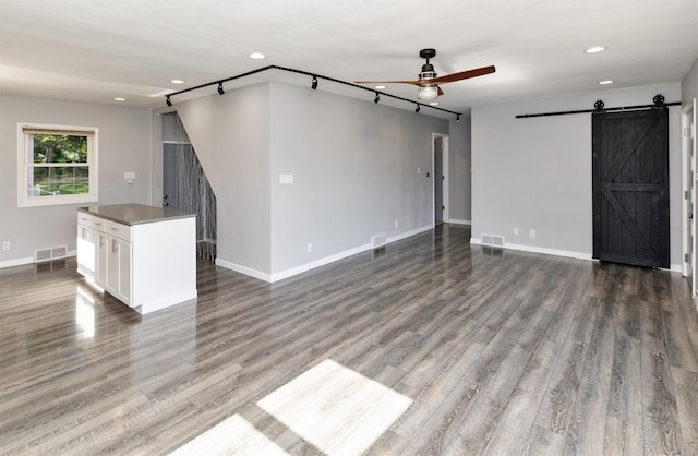 1808 Payton Ave, Des Moines, IA 50315 - unfurnished living room featuring a barn door, ceiling fan, wood finished floors, and recessed lighting